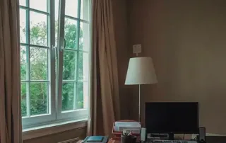 Ventana abatible de PVC de alta gama instalada en home office residencial, diseñada para ofrecer aislamiento térmico y acústico, reduciendo el ruido exterior y manteniendo una temperatura interior confortable.