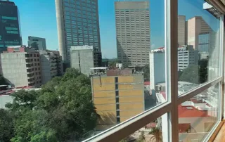 Vista urbana desde ventanas de PVC de alta gama con sistema de aislamiento térmico y acústico, ideales para reducir el ruido exterior en departamentos de ciudad y mejorar el confort interior.