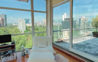 Ventanas panorámicas de PVC de alta gama instaladas en departamento residencial con vista urbana, diseñadas para brindar aislamiento térmico y acústico superior y mayor confort interior.