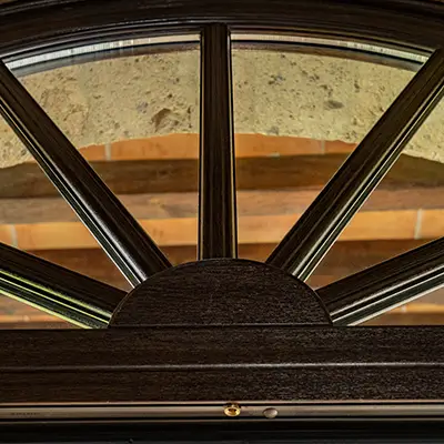 ventana con acabado tipo madera y diseño decorativo semicircular en residencia de lujo