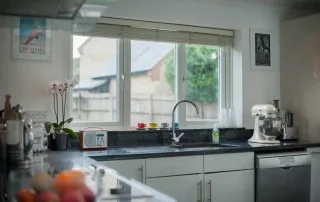 Ventana de PVC de alta gama instalada en cocina contemporánea, diseñada para ofrecer aislamiento térmico y acústico, reducir la entrada de calor y ruido exterior y mejorar la eficiencia energética del hogar.