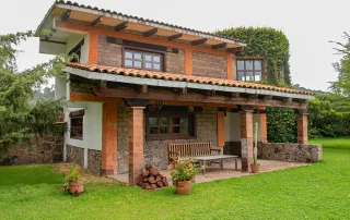 ventanas de PVC instaladas en residencia estilo colonial con fachada de piedra